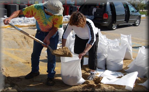 Man and woman filling a sandbag