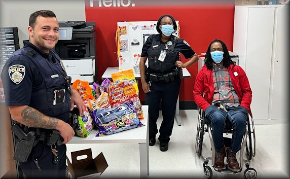 2 police officers and man in wheelchair at a store with Halloween candy