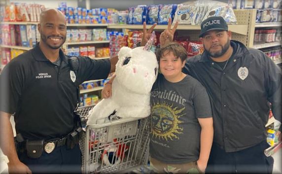 2 police officers with a teenage boy shopping