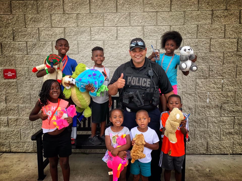 Officer Carlos Dominguez smiles after handing out stuffed animals to local youngsters. 